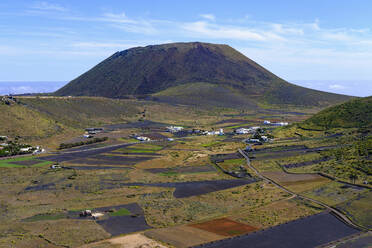 Spanien, Kanarische Inseln, Guinate, Felder vor einem ländlichen Dorf mit dem Vulkan Monte Corona im Hintergrund - SIEF09174
