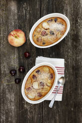 Schalen mit glutenfreiem hausgemachtem Clafoutis mit Kirschen, Pfirsichen und Mandeln - EVGF03504