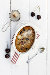 Schüssel mit glutenfreiem hausgemachtem Clafoutis mit Kirschen, Pfirsichen und Mandeln - EVGF03506