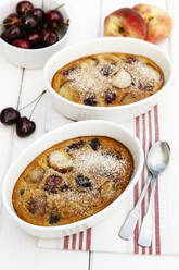 Schalen mit glutenfreiem hausgemachtem Clafoutis mit Kirschen, Pfirsichen und Mandeln - EVGF03507