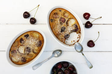 Schalen mit glutenfreiem hausgemachtem Clafoutis mit Kirschen, Pfirsichen und Mandeln - EVGF03517