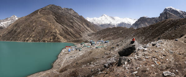 Frau sitzt auf einem Felsen am Gokyo-See, Solo Khumbu, Nepal - ALRF01554