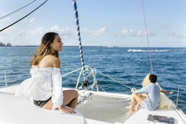 Drei junge Freunde, die einen Sommertag auf einem Segelboot genießen - MGOF04147