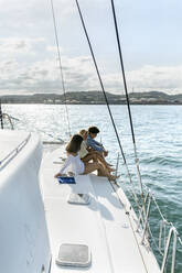 Drei junge Freunde, die einen Sommertag auf einem Segelboot genießen - MGOF04152