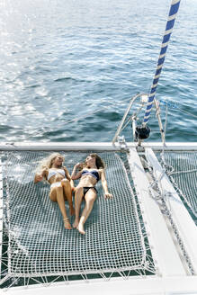 Zwei schöne Frauen, die einen Sommertag auf einem Segelboot genießen - MGOF04153