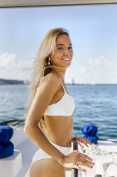 Young woman navigating catamaran on a sailing trip - MGOF04164