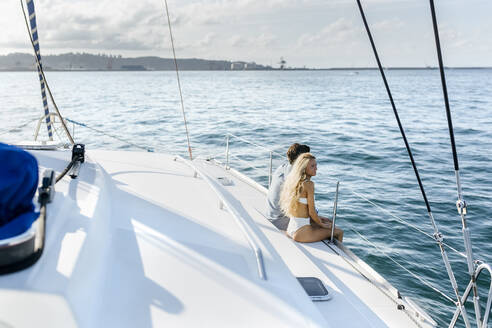 Junges Paar genießt einen Sommertag auf einem Segelboot - MGOF04176