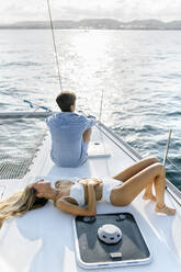 Junges Paar genießt einen Sommertag auf einem Segelboot - MGOF04180