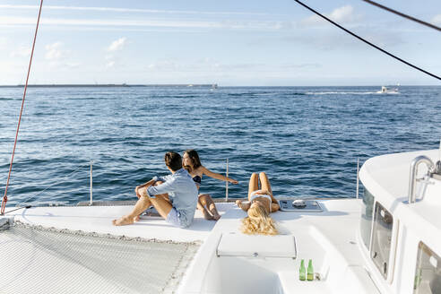 Drei junge Freunde, die einen Sommertag auf einem Segelboot genießen - MGOF04182