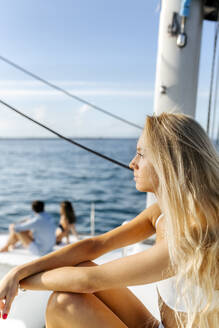 Drei junge Freunde, die einen Sommertag auf einem Segelboot genießen - MGOF04183