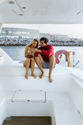 Young couple enjoying a summer day on a sailboat - MGOF04195