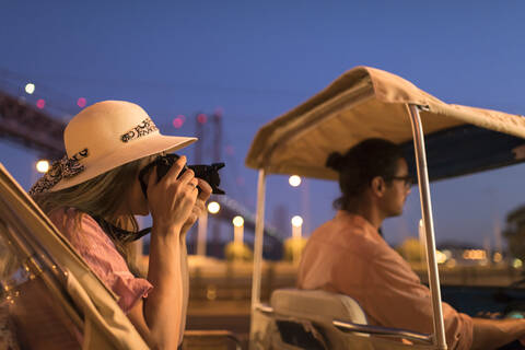 Tourist taking a photo with a camera in a tuk tuk at night, Lisbon, Portugal stock photo