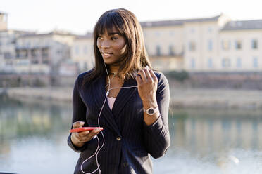 Businesswoman using her smartphone outdoors - GIOF07292