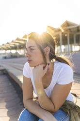 Portrait of young woman at backlight looking at distance - AFVF04078