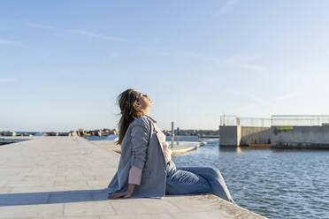 Junge Frau entspannt sich im Sonnenlicht, Barcelona, Spanien - AFVF04088