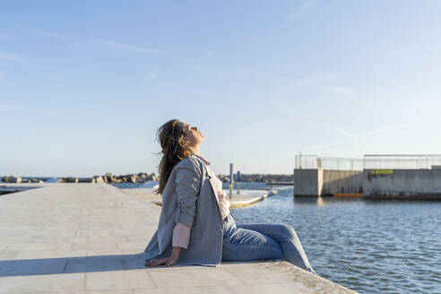 Junge Frau entspannt sich im Sonnenlicht, Barcelona, Spanien - AFVF04088