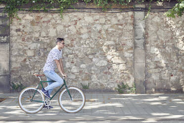 Mann fährt Fahrrad in der Stadt - JNDF00133