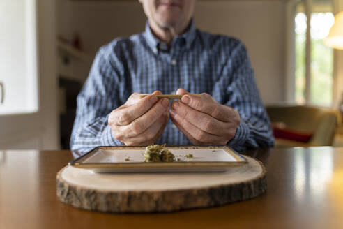 Älterer Mann dreht zu Hause einen Marihuana-Joint - AFVF04120