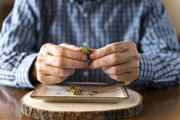 Älterer Mann dreht zu Hause einen Marihuana-Joint - AFVF04122