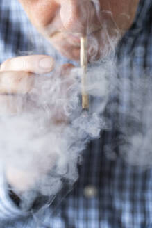 Älterer Mann raucht zu Hause einen Marihuana-Joint - AFVF04124