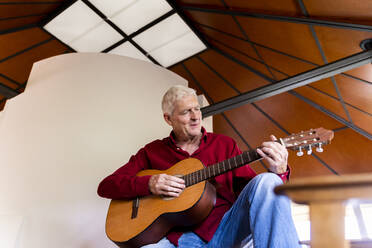 Senior man playing guitar at home - AFVF04135