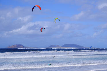 Spanien, Kanarische Inseln, Caleta de Famara, Kiteboarder beim Surfen in Küstennähe - SIEF09184