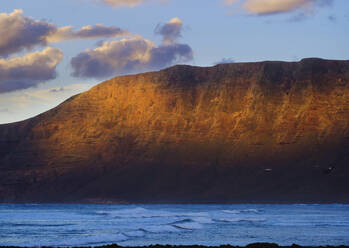 Spanien, Kanarische Inseln, Caleta de Famara, Risco de Famara in der Abenddämmerung - SIEF09190