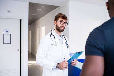 Doctor speaking with patient at hospital reception - ISF22178