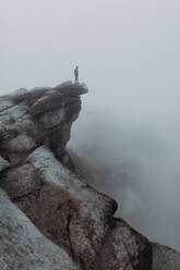 Wanderer genießt den Blick auf das nebelverhangene Tal, Yosemite National Park, Kalifornien, Vereinigte Staaten - ISF22318