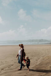 Mutter und Kleinkind gehen am Strand spazieren, Morro Bay, Kalifornien, Vereinigte Staaten - ISF22333