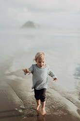 Toddler walking on beach, Morro Bay, California, United States - ISF22341