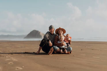 Parents and children sitting on beach, Morro Bay, California, United States - ISF22344