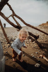 Kleinkind spielt neben Wickiup am Strand - ISF22346