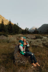 Mutter und kleine Tochter sitzen auf einem Felsen in einem ländlichen Tal, Porträt, Mineral King, Kalifornien, USA - ISF22372