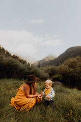 Mutter betrachtet Wildblumen mit ihrer kleinen Tochter in einem ländlichen Tal, Mineral King, Kalifornien, USA - ISF22389