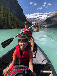 Mann und Junge paddeln an einem Sommertag auf dem Lake Louise, Alberta, Kanada. - CAVF65685