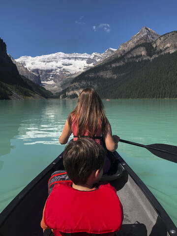 Frau und Junge paddeln an einem Sommertag auf dem Lake Louise, Alberta, Kanada., lizenzfreies Stockfoto