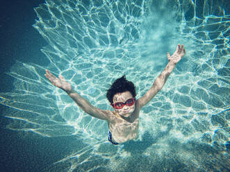 Unterwasserbild eines kleinen Jungen, der in einem Swimmingpool schwimmt. - CAVF65692