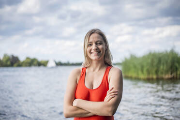 Porträt einer lächelnden Frau, die an einem See steht - BFRF02115