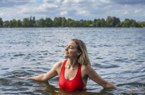 Lächelnde Frau beim Baden in einem See - BFRF02119