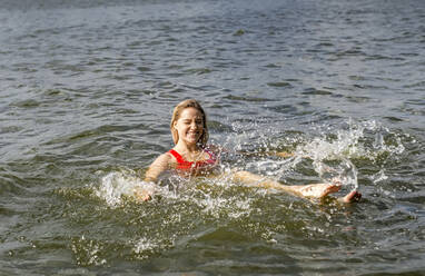 Lächelnde Frau beim Planschen in einem See - BFRF02121