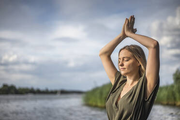 Frau meditiert an einem See - BFRF02128