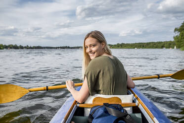 Lächelnde Frau beim Paddeln auf einem See - BFRF02135