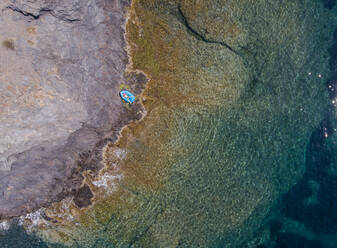 Luftaufnahme eines Kindes in blauem Wasser und schöner Küste an der Costa Brava, Katalonien, Spanien. - AAEF04496