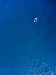 Luftaufnahme einer alten Frau beim Schwimmen im Meer in Spanien. - AAEF04498