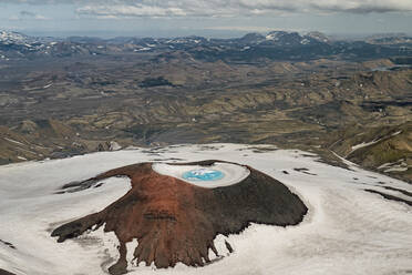 Luftaufnahme eines Vulkankraters in der Gegend von Thórsmörk, Island. Wenn der Schnee schmilzt und die Jahreszeit in den Sommer übergeht, erstrahlt das Gletschereis in einem leuchtenden Tiefblau, Island. - AAEF04531