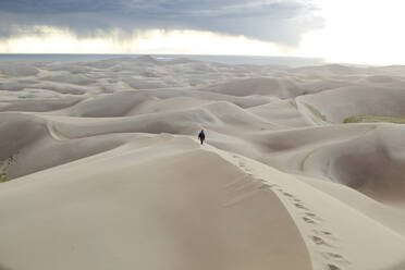 Ein Mann, der oben auf den Großen Sanddünen in Süd-Colorado, USA, spazieren geht. - AAEF04545