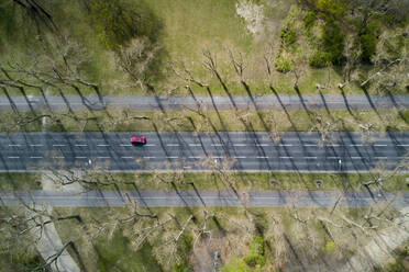 Blick aus der Vogelperspektive auf ein rotes Auto, das in Berlin fährt. - AAEF04549