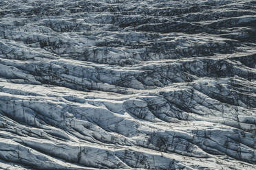 Luftaufnahme des Svínafellsjökull-Gletschers: Die schwarzen Linien oder Streifen im Eis stammen von der Asche vergangener Vulkanausbrüche, Island. - AAEF04587