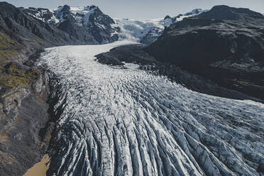 Luftaufnahme des Svínafellsjökull-Gletschers: Die schwarzen Linien oder Streifen im Eis stammen von der Asche vergangener Vulkanausbrüche, Island. - AAEF04588